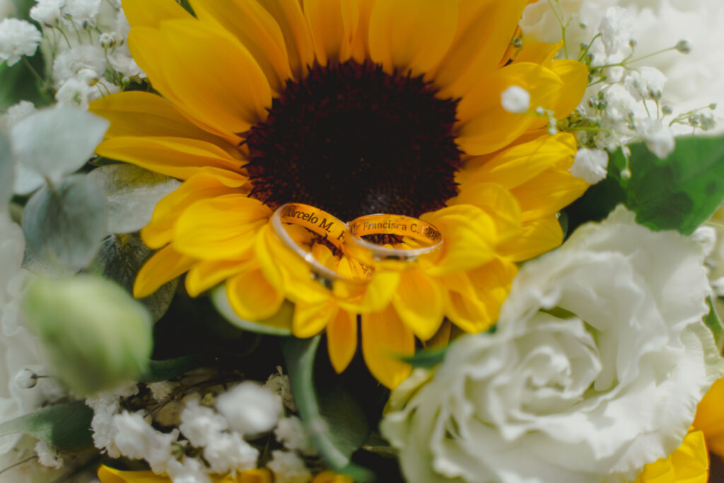 Anillos de boda sobre ramo con girasoles por fotografía y video de bodas en Chile Día 7