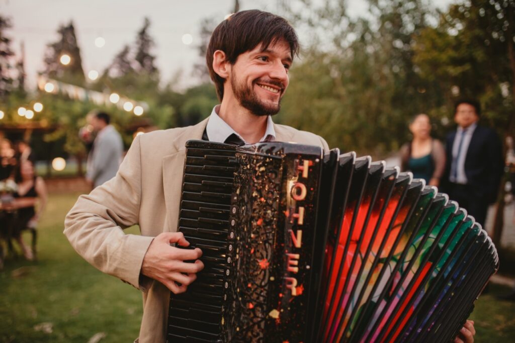 Pablo Téllez interpretando acordeón en evento de matrimonio en Santiago con equipo profesional de amplificación.