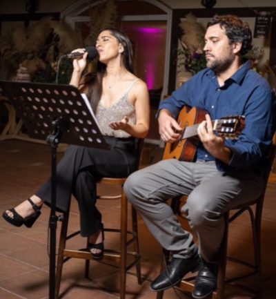 Cantante Karen Mellafe animando recepción de boda con guitarrista en evento chileno